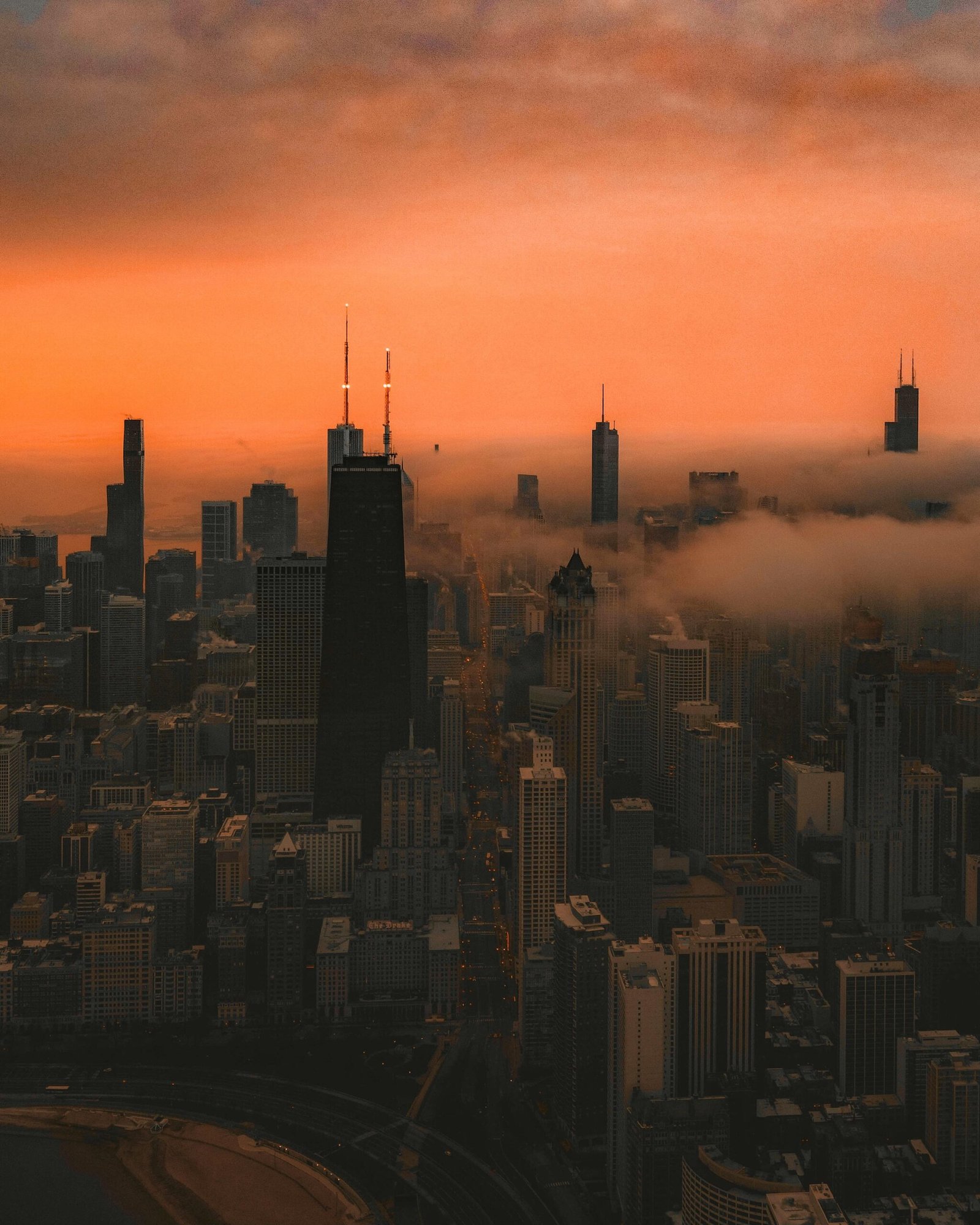 A stunning aerial shot of Chicago's skyline with skyscrapers silhouetted against a vibrant sunset.